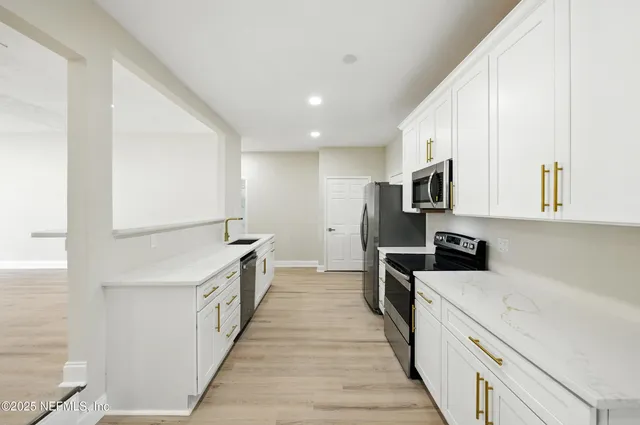 a kitchen with stainless steel appliances a sink stove and cabinets