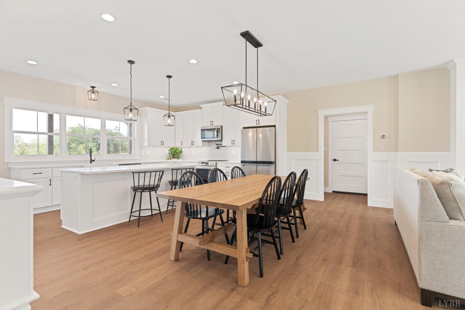 6605 Forest Road Goode, VA 24556 - Photo 20 of 58 a dining area with furniture a chandelier and wooden floor