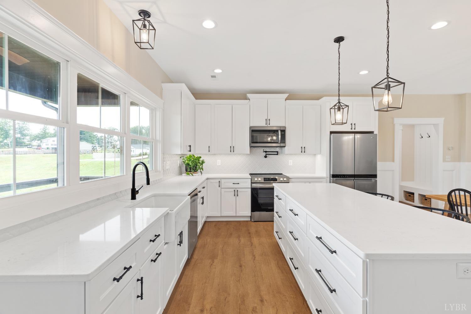 6605 Forest Road Goode, VA 24556 - Photo 24 of 58 a kitchen with kitchen island white cabinets sink and stainless steel appliances