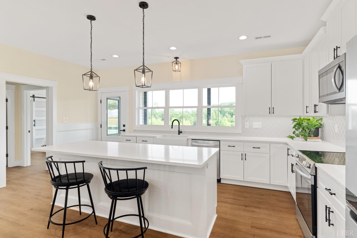 6605 Forest Road Goode, VA 24556 - Photo 25 of 58 a kitchen with stainless steel appliances granite countertop a sink a stove and a center island