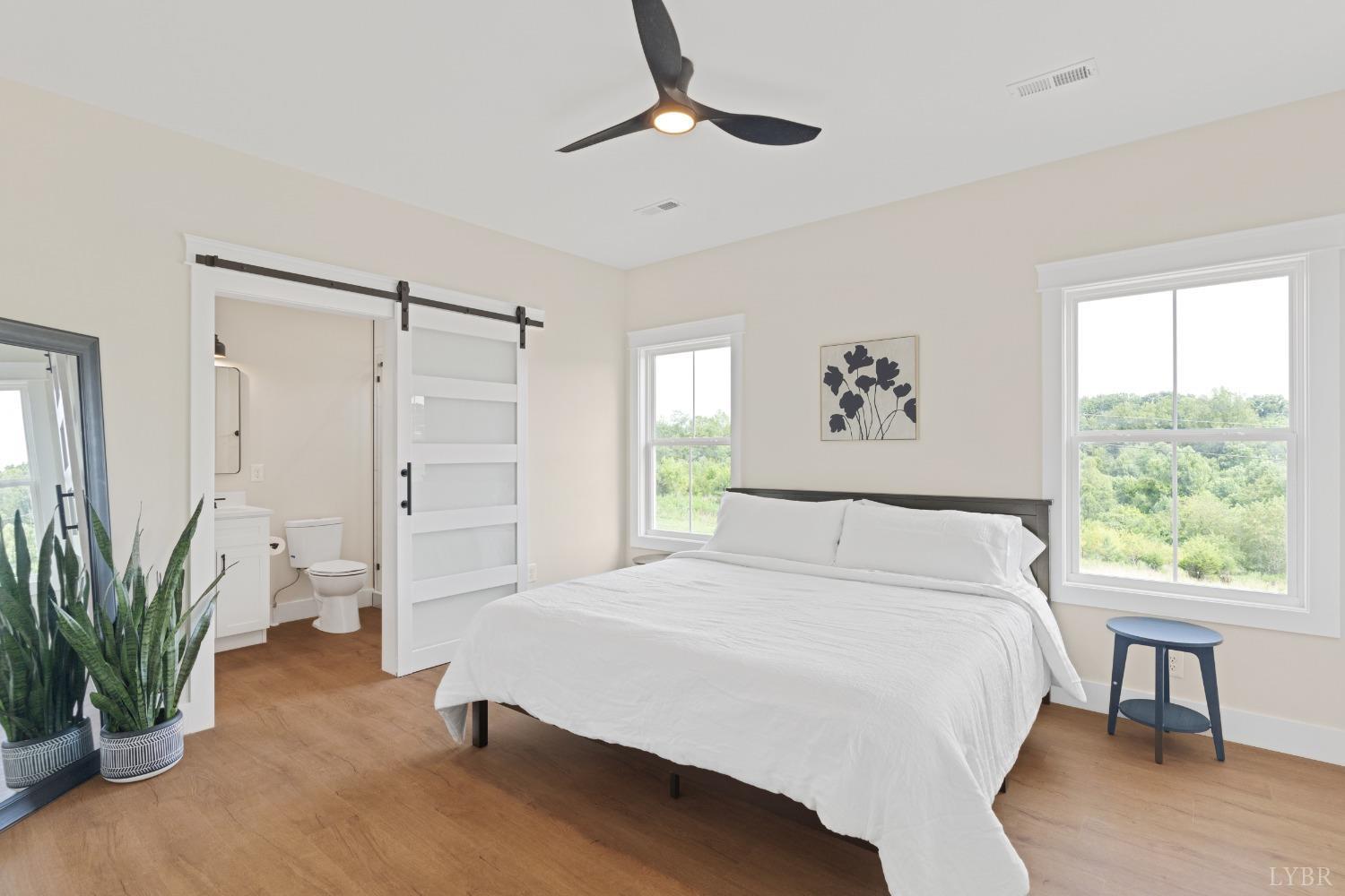 6605 Forest Road Goode, VA 24556 - Photo 37 of 58 a spacious bedroom with a bed and a chandelier