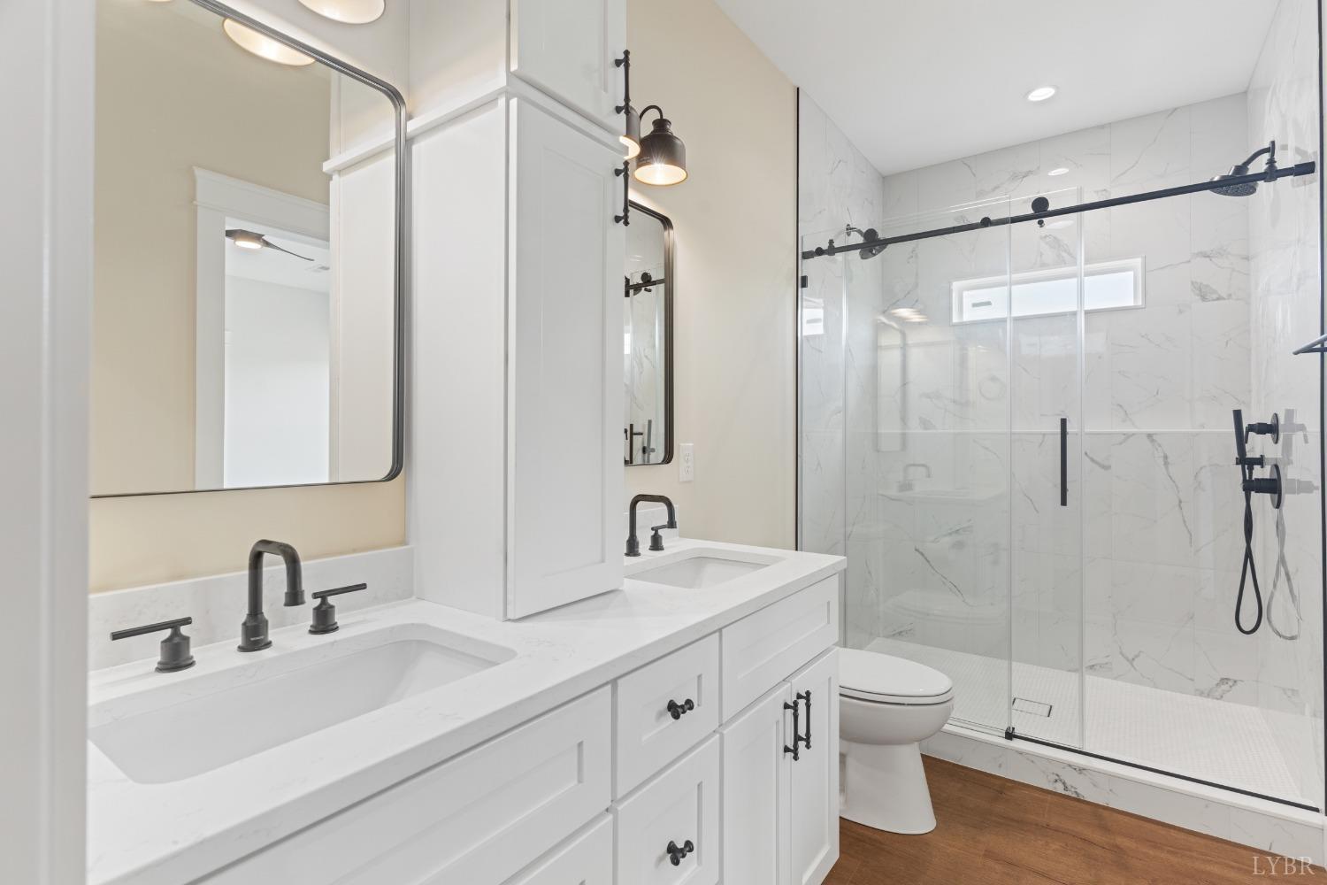6605 Forest Road Goode, VA 24556 - Photo 42 of 58 a bathroom with a double vanity sink toilet mirror and shower