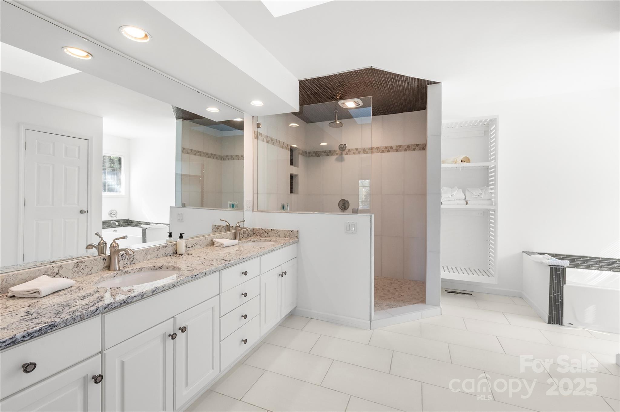 108 June Court Lake Lure, NC 28746 - Photo 22 of 46 a spacious bathroom with a granite countertop sink a shower and a mirror