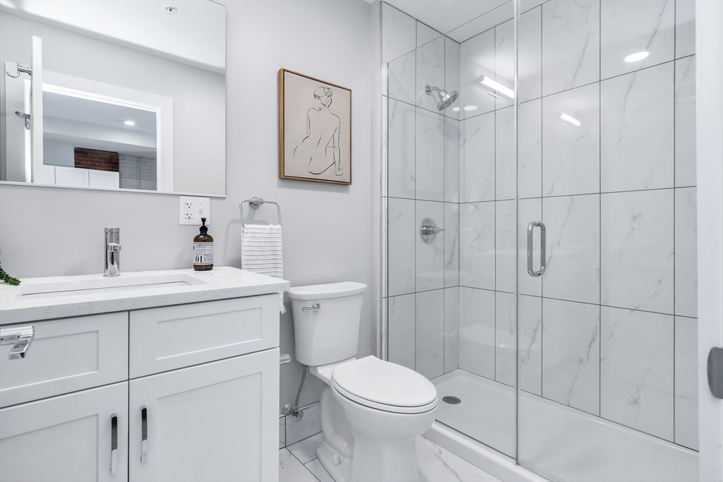 200 Merrimack Street, Unit 201 Haverhill, MA 01830 - Photo 15 of 17 a bathroom with a toilet sink vanity and mirror