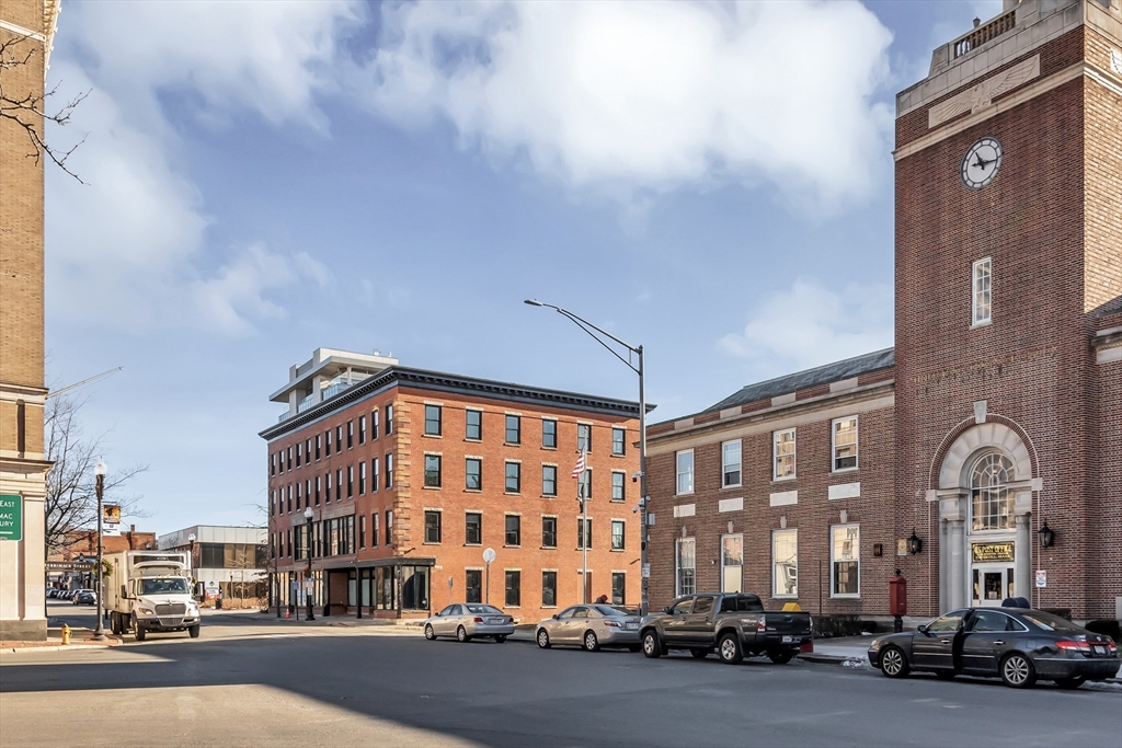 200 Merrimack Street, Unit 201 Haverhill, MA 01830 - Photo 3 of 17 a city street lined with parked cars and buildings