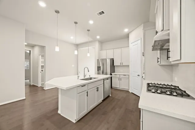 a kitchen with stainless steel appliances kitchen island a sink a stove and a refrigerator