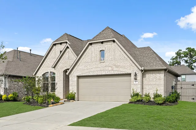 a front view of a house with a garden and plants