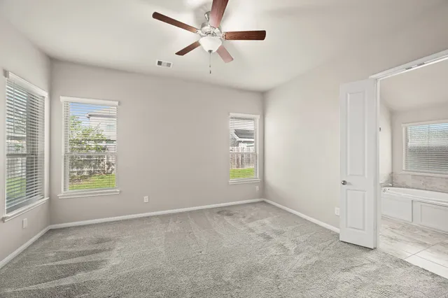 an empty room with a window and a ceiling fan