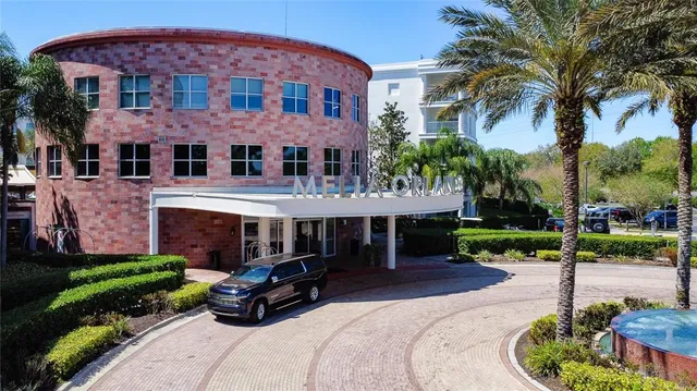 a front view of a house with garden and trees