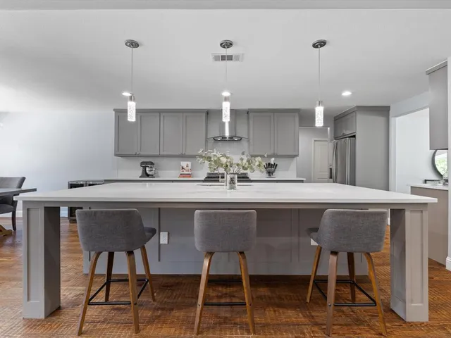 a kitchen with kitchen island a dining table and chairs
