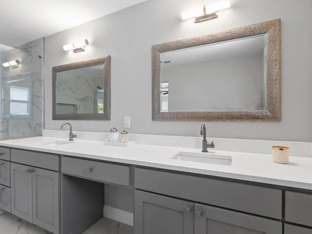 a bathroom with double sink and two mirror