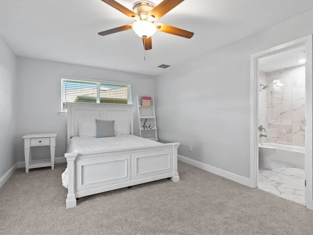 a bedroom with a bed and a ceiling fan