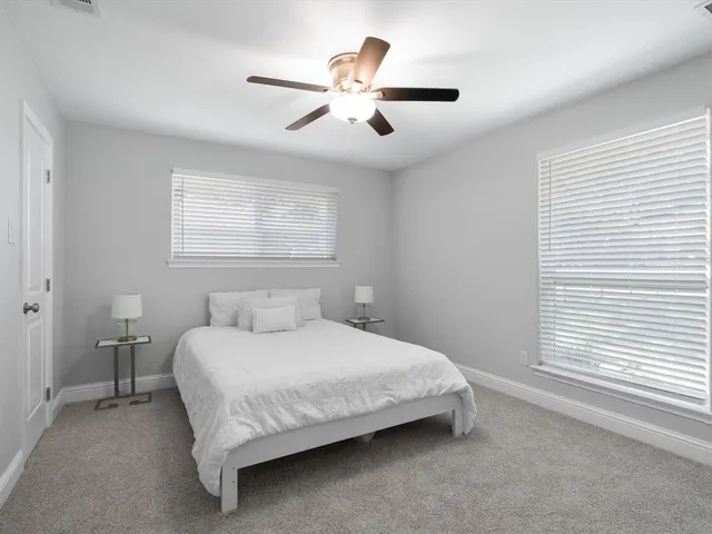 a bedroom with a bed and a ceiling fan
