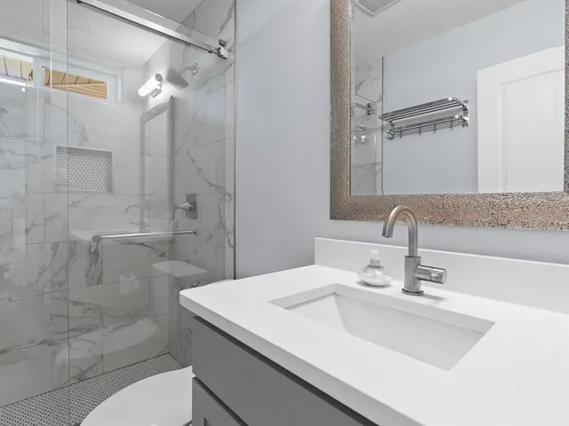 a bathroom with a sink toilet and shower