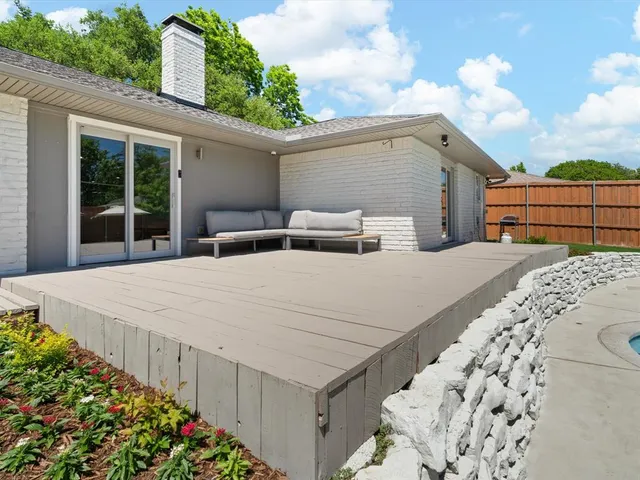 a row of white house with a large window and flower plants