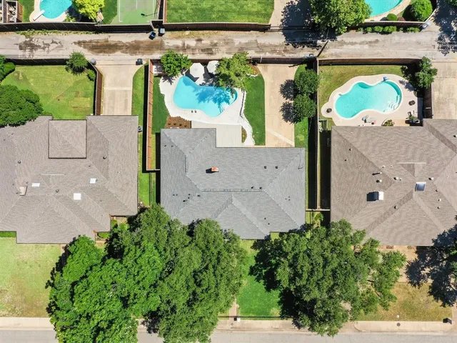 an aerial view of a house with a yard and a large parking space
