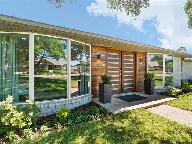 a view of a porch with a floor to ceiling window and garden