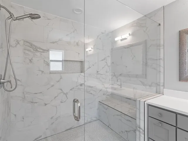 a bathroom with a granite countertop sink a toilet and shower
