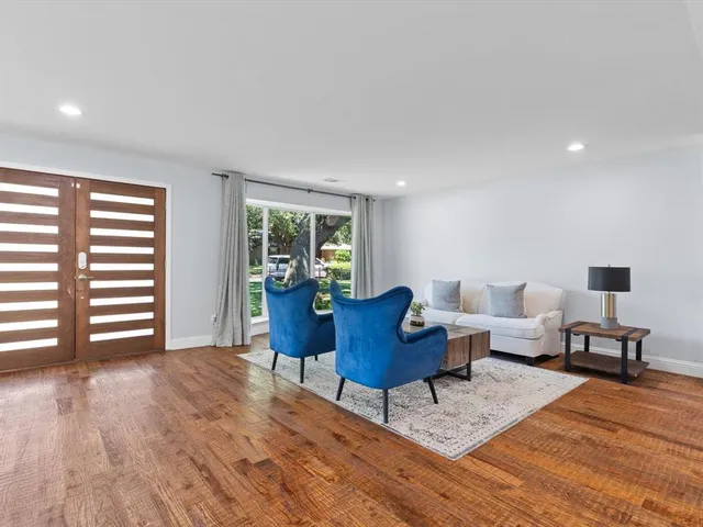 a living room with furniture and a wooden floor