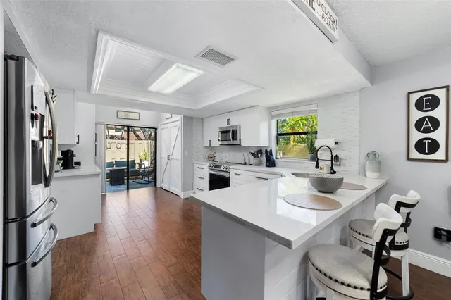 a kitchen with a table chairs refrigerator and cabinets