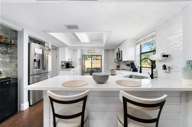 a dining room with furniture a large window and wooden floor