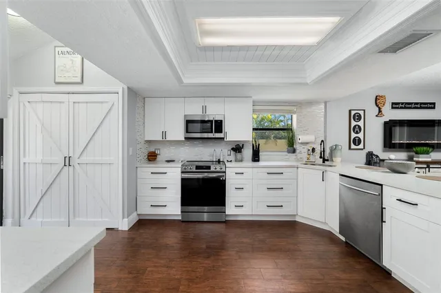 a kitchen with white cabinets and stainless steel appliances