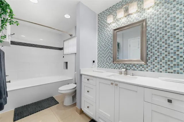 a bathroom with a double vanity sink mirror and toilet