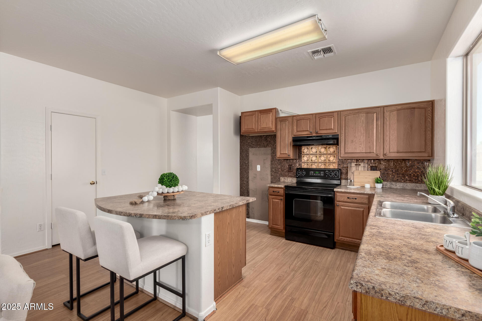 3129 West Fremont Rd. Phoenix, AZ 85041 - Photo 9 of 30 a kitchen with granite countertop stainless steel appliances a stove top oven a sink a dining table and chairs