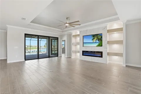 a view of an empty room with window and wooden floor