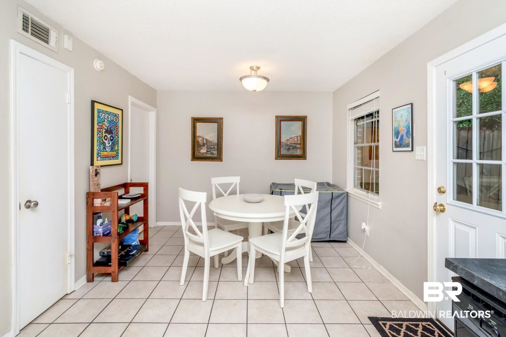 118 Du Rhu Drive, Unit H Mobile, AL 36608 - Photo 10 of 19 Dining area featuring tile flooring, a window with horizontal blinds, and a white paneled door with glass inserts providing outdoor access