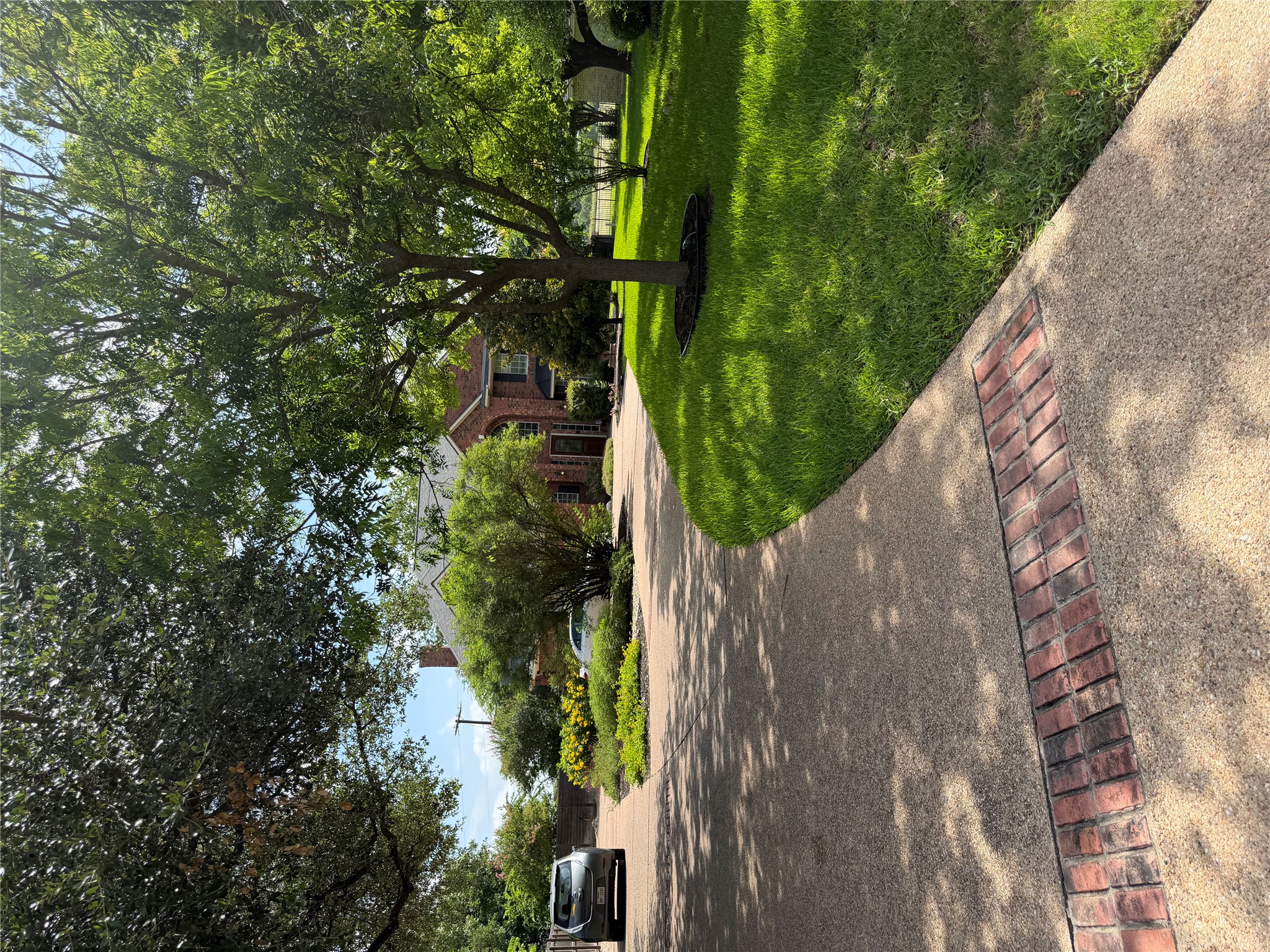 13 Oak View Round Rock, TX 78664 - Photo 23 of 30 A graceful circle driveway, accented with brick, leads to a timeless brick residence amidst lush, mature landscaping.
