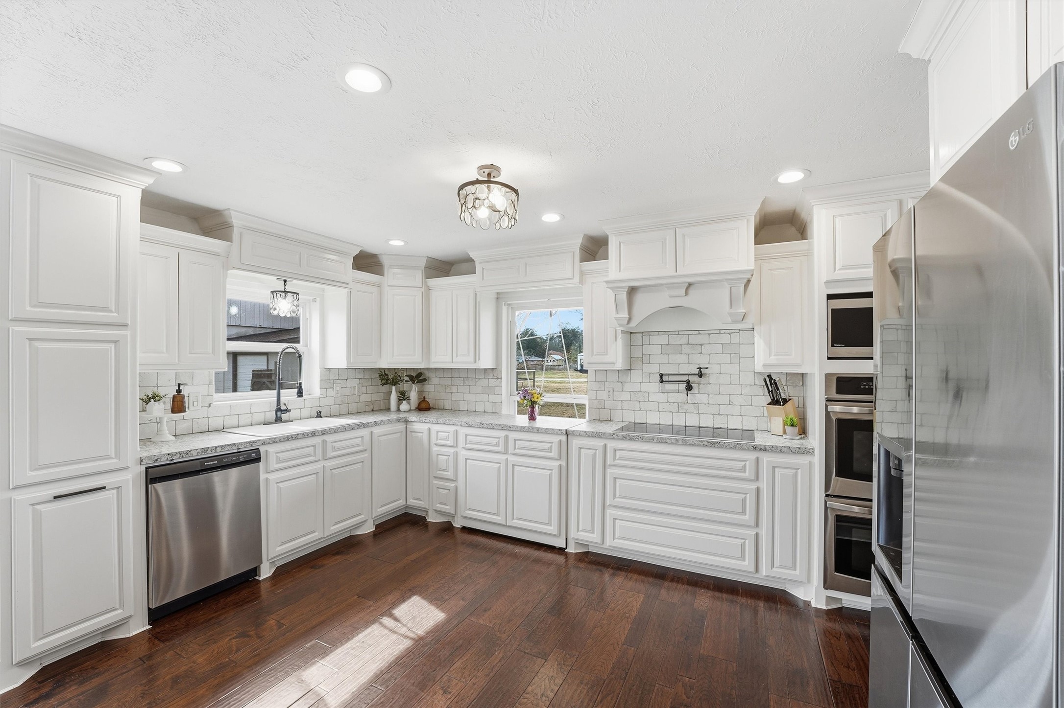 17663 Gardenia Lane New Caney, TX 77357 - Photo 5 of 37 a kitchen with white cabinets and stainless steel appliances