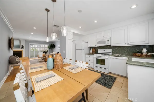 a kitchen with stainless steel appliances kitchen island granite countertop a sink and white cabinets