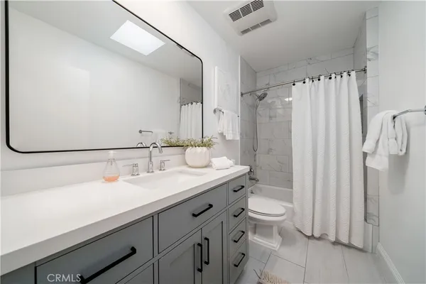 a bathroom with a double vanity sink toilet and shower