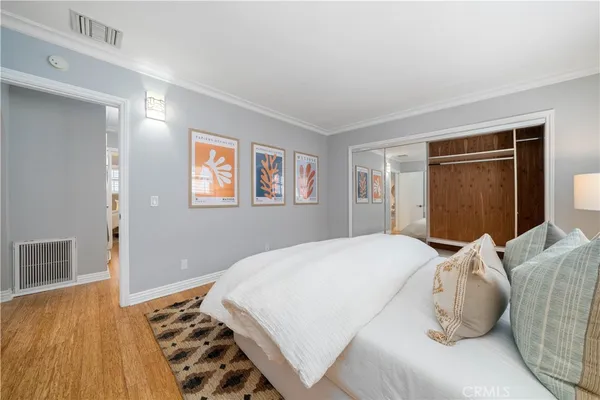 a bedroom with a bed and wooden floor