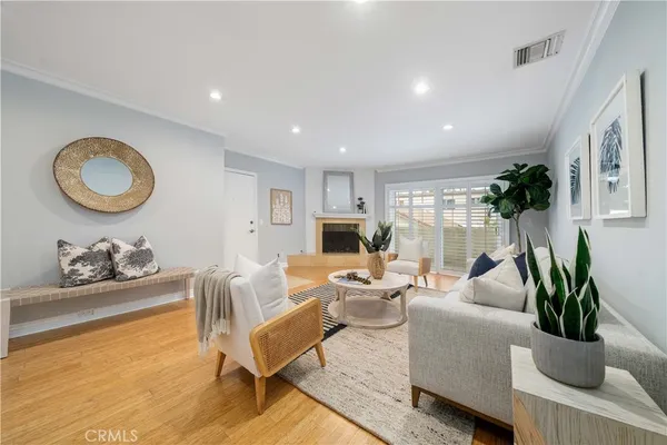 a living room with furniture potted plant and kitchen view