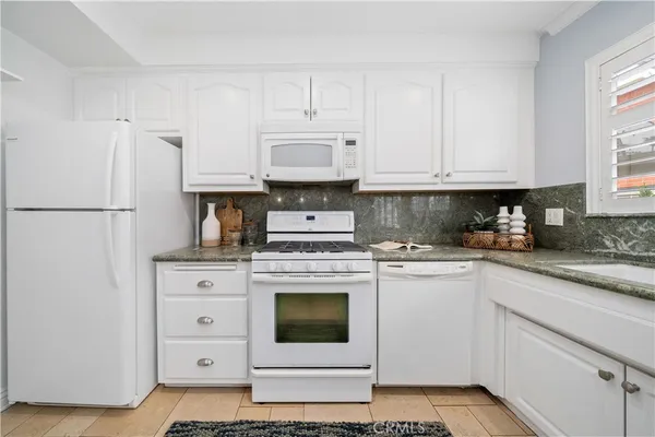 a kitchen with cabinets appliances and a window