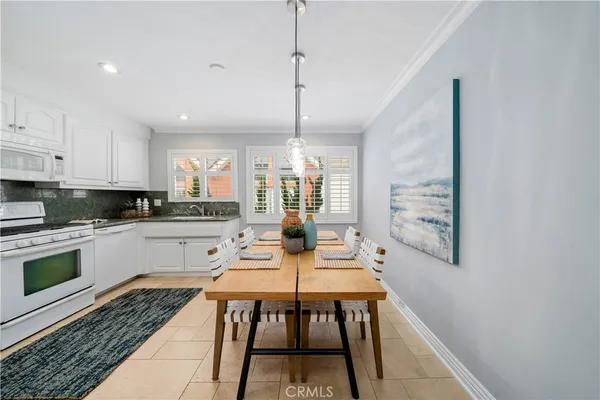 a open kitchen with stainless steel appliances granite countertop a stove a sink dishwasher and a microwave with wooden floor
