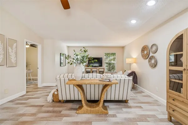 a room with wooden floor and ceiling fan