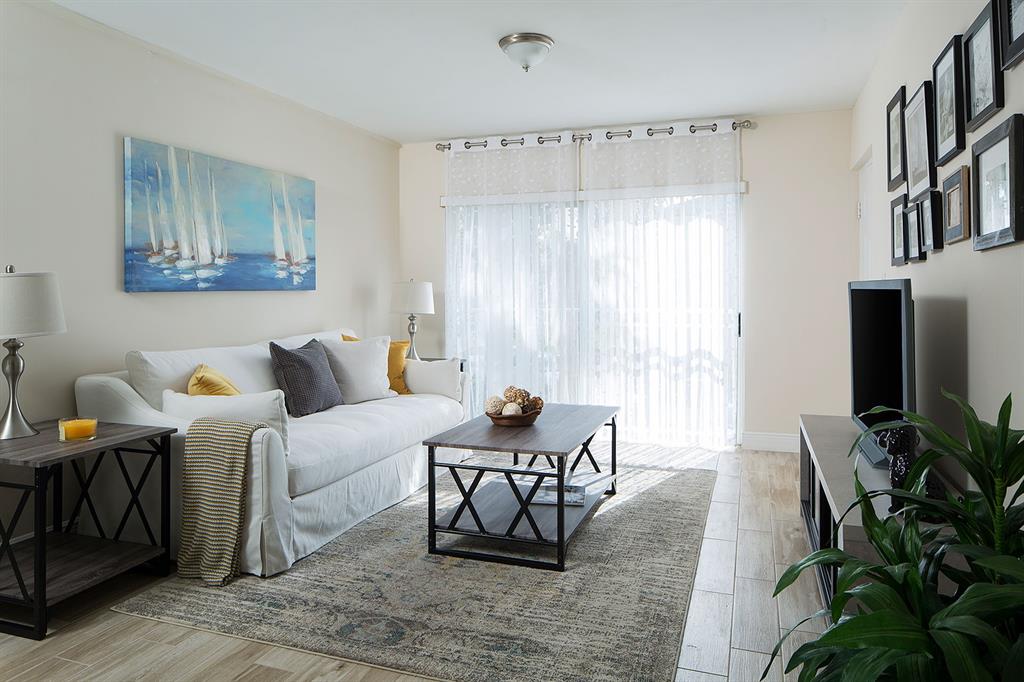 13901 Southwest 122nd Avenue, Unit 8306 Miami, FL 33186 - Photo 2 of 8 a living room with furniture and a flat screen tv