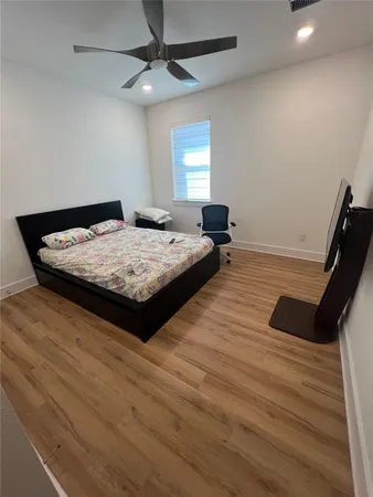 a living room with hard wood floors and a ceiling fan