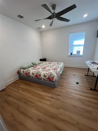 a bedroom with a bed and wooden floor