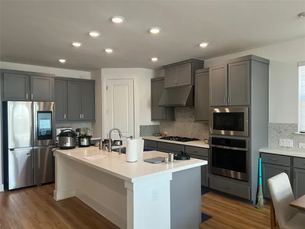 a kitchen with kitchen island a sink stainless steel appliances and cabinets