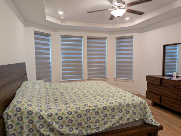 a bedroom with a bed and dresser with mirror