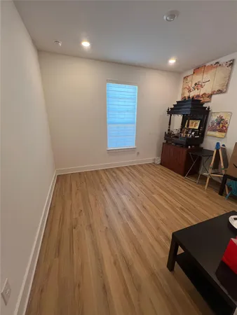 a room with wooden floor and lots of furniture