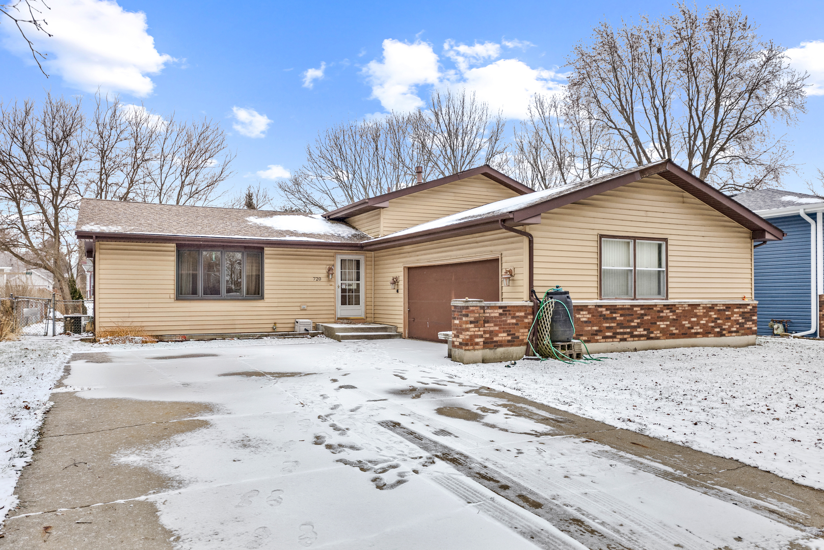 a front view of a house with a yard covered in snow