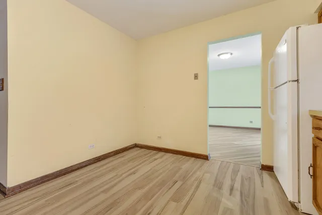 an empty room with wooden floor and a bathroom