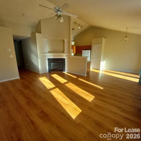 a view of empty room with wooden floor and fireplace