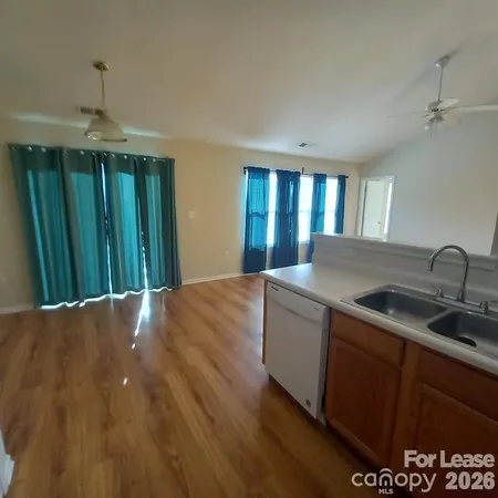 a kitchen with kitchen island granite countertop a sink stainless steel appliances and cabinets