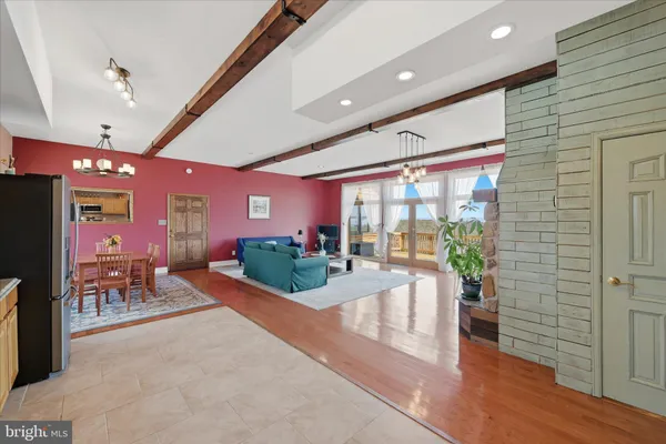 a bathroom with a granite countertop toilet a sink a mirror and a window